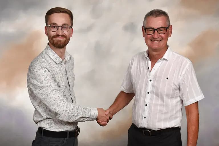Deux hommes se serrent la main avec un fond flou, symbolisant un partenariat de confiance. Une ambiance professionnelle et amicale.