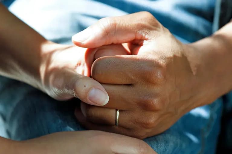 Deux mains se tenant, symbolisant le soutien et la proximité humaine, éclairage naturel.